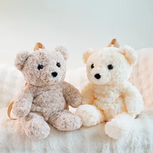 Dettaglio in primo piano di simpatici zaini in peluche orsetto di rosa in morbidi toni beige.