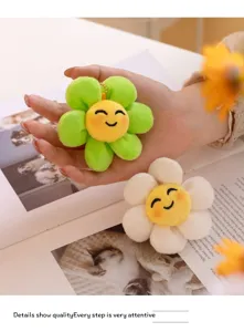 Simpatico portachiavi in peluche con fiore sorridente, materiale morbido in verde e bianco.