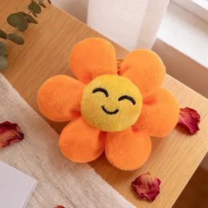Primo piano dettagliato di un grazioso ciondolo di fiore in peluche arancione con viso.