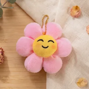 Dettaglio pendente girasole sorridente in peluche, simpatico portachiavi peluche, petali rosa.