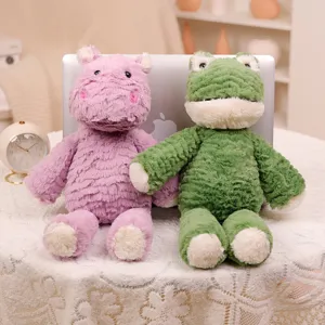 Detalle de bonitos peluches de hipopótamo y rana, suaves animales de peluche para regalo.