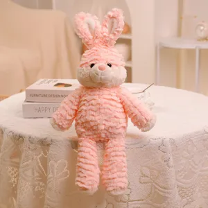 Primer plano de un tierno conejito de peluche rosa con textura de volantes y decoración de habitación.
