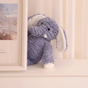 Juguete de peluche de elefante azul con tela texturizada y detalles blancos vista de detalle