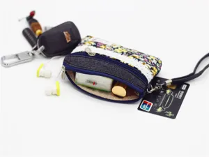 Floral print denim coin purse with zipper closure and strap, detail view showing interior capacity.
