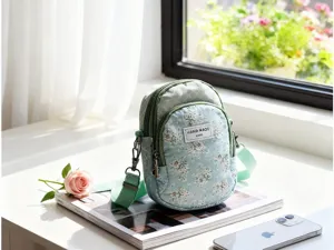 Kleine Handy-Umhängetasche mit Blumenmuster, mehreren Fächern und verstellbarem Riemen.