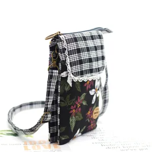 Detail shot of a stylish cotton crossbody phone bag with plaid flap and floral body.