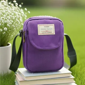 Borsa a tracolla viola in nylon, vista dettagliata della borsa con etichetta e cinghia.