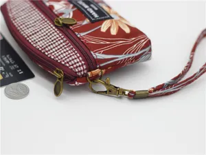 Fabric coin purse detail featuring double zippers, floral pattern and handy wrist strap.