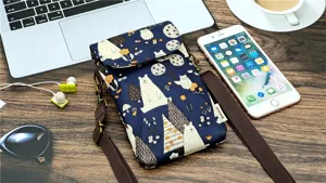 Detail view of cute bear pattern waterproof crossbody phone bag with adjustable brown strap.