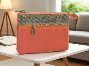 Borsetta portamonete compatta in tela multistrato con elegante contrasto di tessuti e zip.