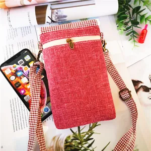 Detailed view of red cotton linen cross-body phone bag with houndstooth strap and zipper.
