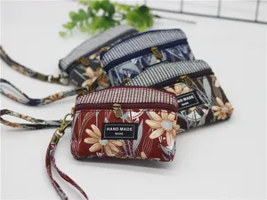 Canvas floral coin purse with wrist strap and double zippers for women daily use and casual storage.