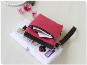Red canvas crossbody mobile phone bag with brown leather flap wrist strap and zipper pocket.