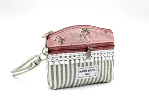 Fabric coin purse with floral pattern, stripes, lace trim, and convenient wrist strap.
