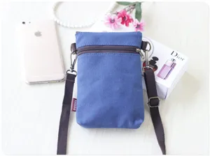 Detail view of the small blue canvas crossbody phone bag showcasing texture and strap detail.