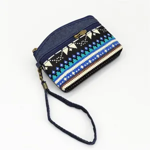 Close-up detail of the ethnic style denim coin purse zipper and woven fabric texture.