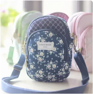 Detailaufnahme der gesteppten floralen Mehrschicht-Umhängetasche mit verstellbarem Riemen.