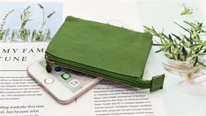 Vista dettagliata del portamonete in tela verde, pratica pochette con zip per organizzare.