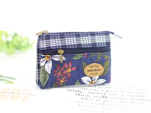 Close-up detail of the multi-layer fabric coin purse with floral pattern and secure zipper.