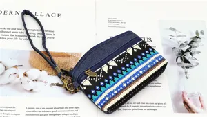 Close-up detail of ethnic style denim coin purse with double zip and wrist strap, stylish.