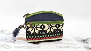 Ethnic style fabric coin purse with double zipper and wrist strap, detailed accessory view.