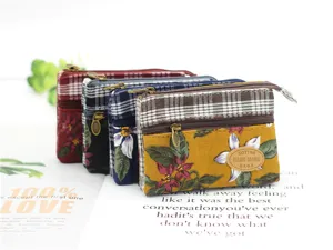 Detail view of multi-layer floral canvas coin purse with zipper and plaid pattern design.