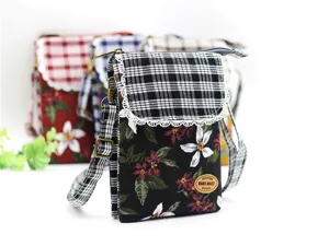 Close up detail of cotton floral crossbody phone bag, plaid flap, lace trim, multi layer.