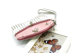 Detail view of fabric double zipper coin purse featuring pink floral and elegant striped pattern.