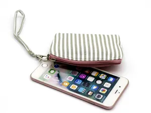 Close-up detail of the striped fabric coin purse featuring a handy wrist strap and metal zipper.