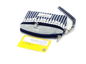 Close-up detail of blue and white striped fabric coin purse with lace trim and wrist strap.