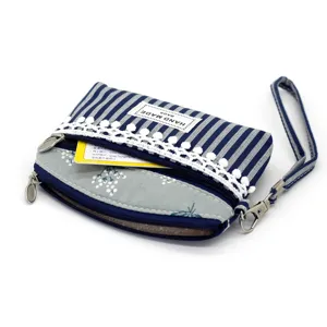 Portamonete in tessuto a righe blu e bianche con pizzo, doppie zip e comodo cinturino.