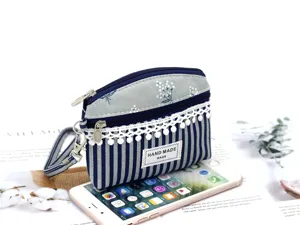 Detailed view of the cute floral fabric coin purse with wrist strap and zipper closure.