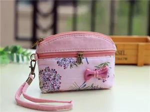 Pink floral fabric coin purse with double zippers and wrist strap, compact mini storage bag.