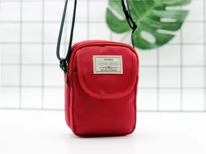 Vista dettagliata della borsa a tracolla rossa in nylon per cellulari, tasca frontale e etichetta.