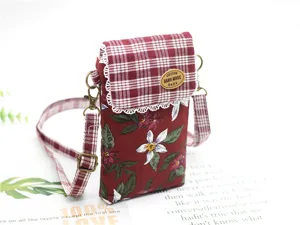 Floral cotton crossbody phone bag with red plaid flap, lace trim, and adjustable strap.