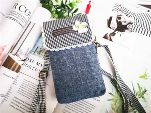 Close-up of houndstooth denim crossbody phone bag with lace trim and sweet flower detail.