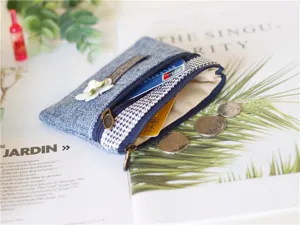 Close-up detail of cotton linen coin purse with double zippers, delicate flower decor and card slot.