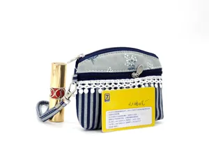 Detail view of blue and white striped fabric coin purse with floral top and lace trim decoration.