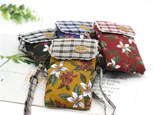 Detail shot of multi-layer cotton floral print crossbody phone bags with plaid flap design.