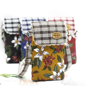 Floral print cotton cross-body mobile phone bag with plaid flap and adjustable strap.