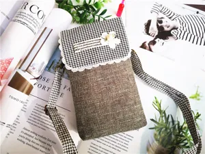 Detailed view of the casual linen crossbody phone bag with houndstooth flap and flower.