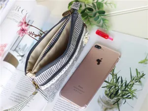 Λεπτομερής εικόνα της τσάντας clutch με φερμουάρ από λινό και μοτίβο houndstooth για οργάνωση.