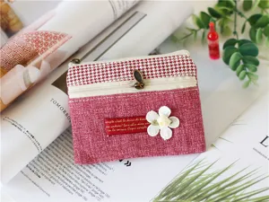 Linen coin purse zipper pouch with houndstooth and floral detail, close-up texture view.