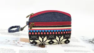 Ethnic style canvas coin purse with double zippers, wrist strap and vibrant woven pattern.
