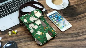 Green forest cartoon print waterproof crossbody phone bag detail showing fabric texture and strap.