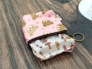 Detailopname van het roze beer print tasje, ritssluiting en metalen sleutelhanger ring.