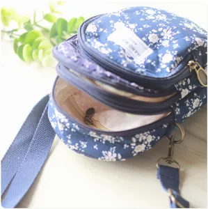 Blaues, mehrlagiges Umhängetasche für Handys mit Blumenmuster und verstellbarem Riemen.