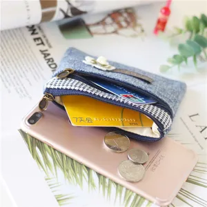 Denim coin purse with double zipper, floral decoration, and compact card holder design.