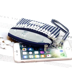 Blue and white striped canvas coin purse with lace trim, double zipper and wrist strap.