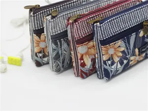 Multi-layer cotton coin purse detail showing four zipped pouches with floral and houndstooth patterns.